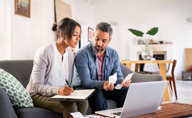 Couple sitting on couch with laptop