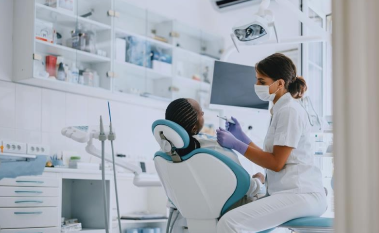 Person in dentist chair getting dental exam from dentist