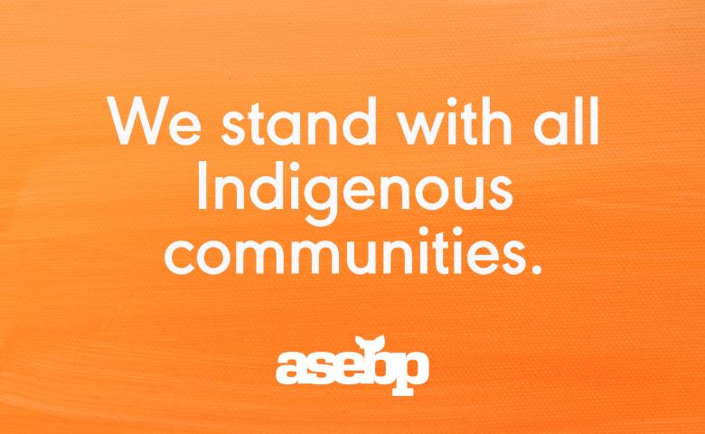 Orange background with white text that reads &quot;We stand with all Indigenous communities.&quot;
