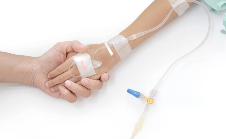 Patient with IV holding a loved one&#039;s hand